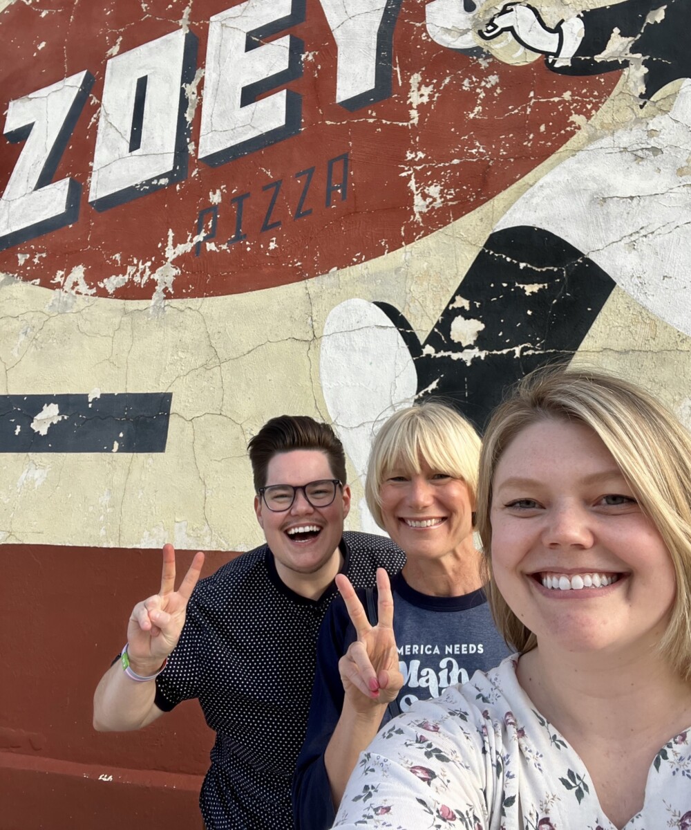 Three Main Street America Staff members standing in front of a mural in Marion, Iowa.