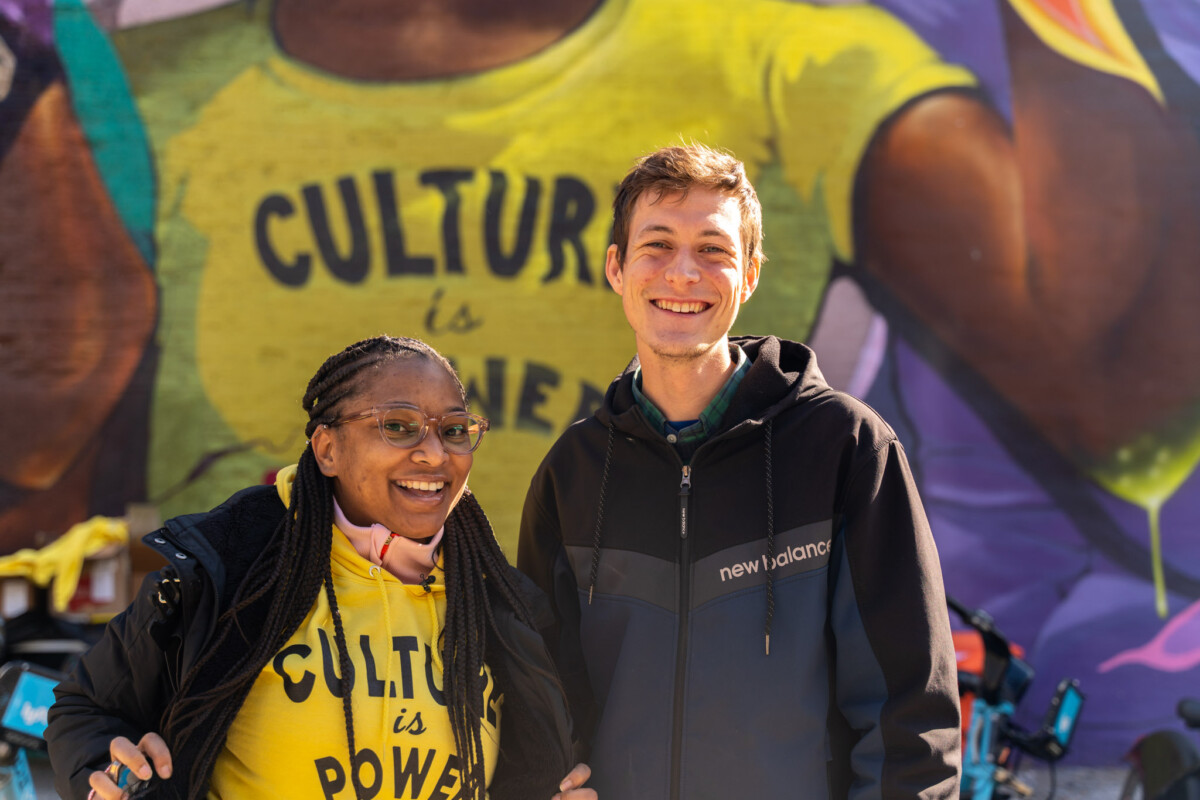 Una mujer y un hombre frente a un mural en el que se lee "La cultura es poder" en Chicago, Illinois.