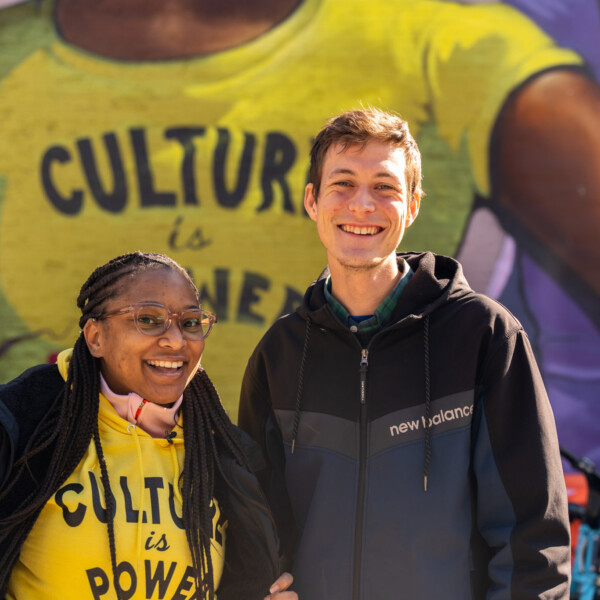 Una mujer y un hombre frente a un mural en el que se lee "La cultura es poder" en Chicago, Illinois.