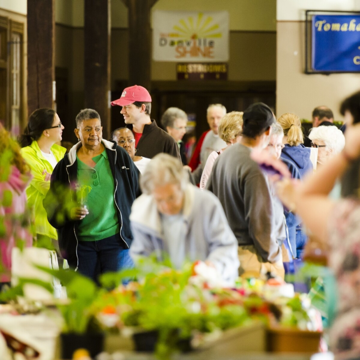 People shopping at an indoor farmers market.