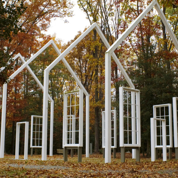 White building frame in a forest clearing.