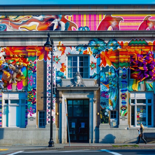 Edificio bancario histórico con una colorida instalación artística en la fachada.