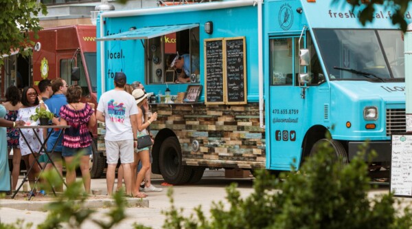 People waiting in line in front of a blue food truck