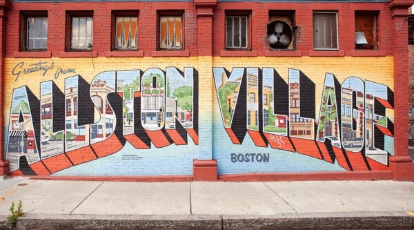 A mural with the words "Greetings from Allston Village"