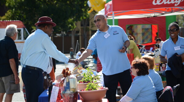 Two men shake hands at a community event