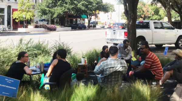 People sitting at tables in a parklet