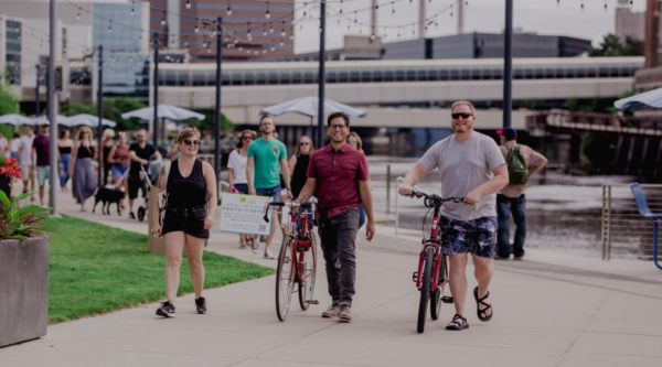 Gente paseando con bicicletas por el centro de la ciudad