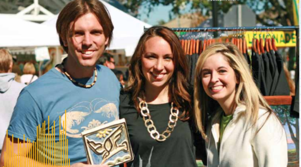 Un hombre y dos mujeres posan para una foto en un festival en el centro de la ciudad