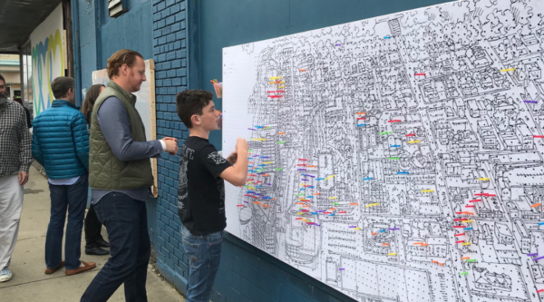 Participación en un ejercicio de cartografía del centro de la ciudad colocando chinchetas en un gran mapa.