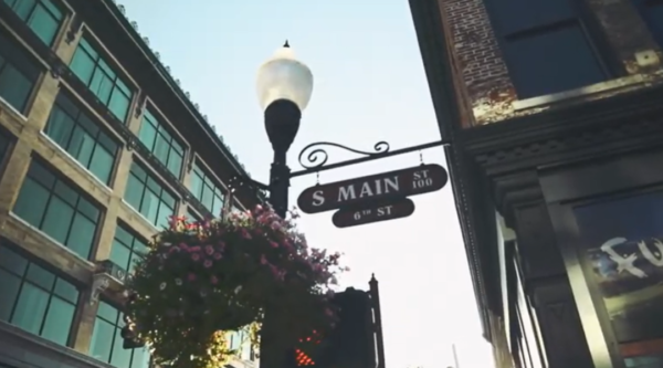 A street sign reading "main street" on a lamp post with a flower box