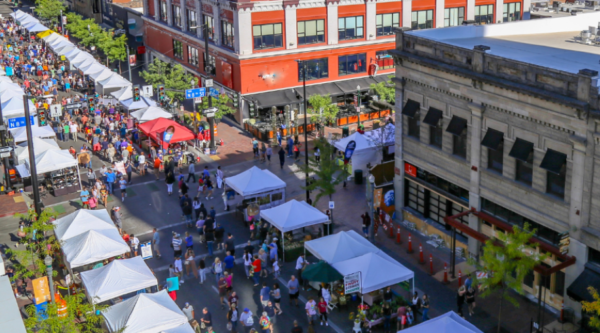 Aerial photograph of a downtown festival with vendors along a historic street