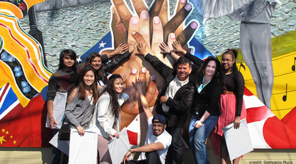Group of people standing in front of a mural