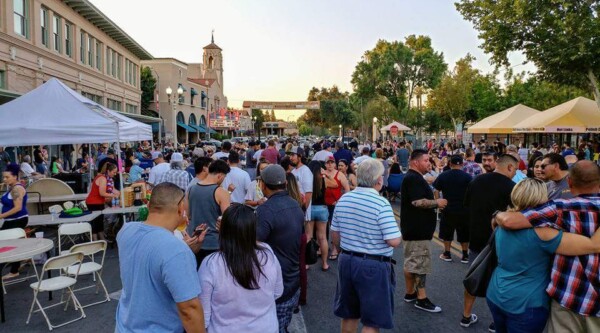 Crowd of people at outdoor festival in downtown district.
