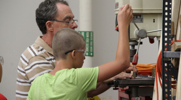 Fab Lab ICC director Jim Correll helps a student create a project on the maker equipment.