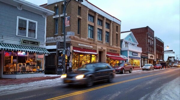 Cars driving down historic downtown street in winter.