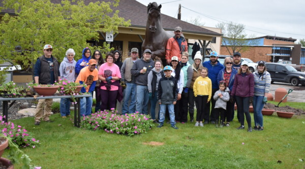 Foto de grupo de los voluntarios que ayudaron a trasplantar y colgar más de 225 cestas de flores en las farolas históricas de Main Street.