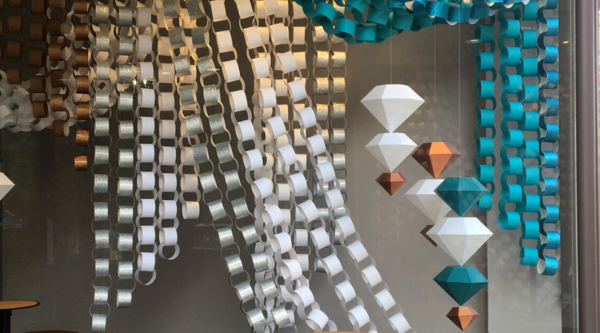 A storefront decorated with paper chains and paper diamonds