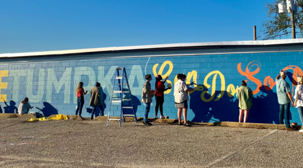 People painting a mural reading " Together, Wetumpka Can"