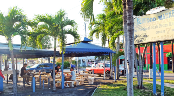 The Plaza Seafood Market in Little Santo Domingo: an outdoor eatery with awnings and palm trees