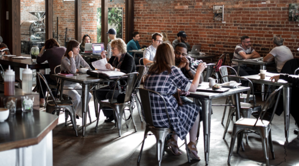 Gente sentada en las mesas de una cafetería