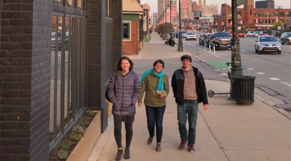 Erin Barnes y dos amigos caminan por una acera en una ciudad