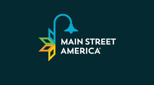 Logotipo de Main Street America sobre un campo de color oscuro.
